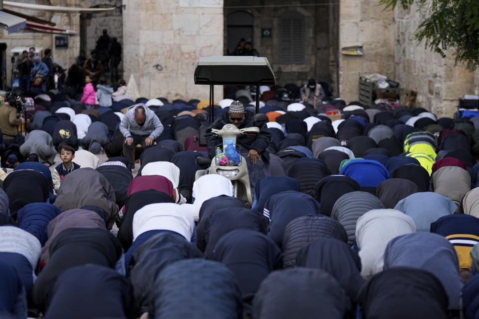 Muslim worshippers perform Friday prayers outside the Lion's Gate entrance to the Al Aqsa Mosque compound during the Muslim holy month of Ramadan in Jerusalem's Old City, Friday, March 15, 2024. (AP Photo/Ohad Zwigenberg)