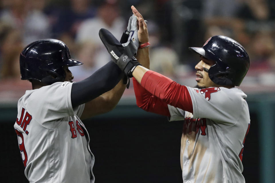 Boston Red Sox's Mookie Betts, right, and Boston Red Sox's Jackie Bradley Jr. celebrate after scoring on a double by Rafael Devers during the sixth inning of the team's baseball game against the Cleveland Indians, Tuesday, Aug. 13, 2019, in Cleveland. (AP Photo/Tony Dejak)