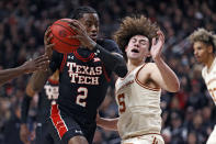 Texas Tech's Davion Warren (2) dribbles the ball around Texas' Devin Askew (5) during the first half of an NCAA college basketball game on Tuesday, Feb. 1, 2022, in Lubbock, Texas. (AP Photo/Brad Tollefson)
