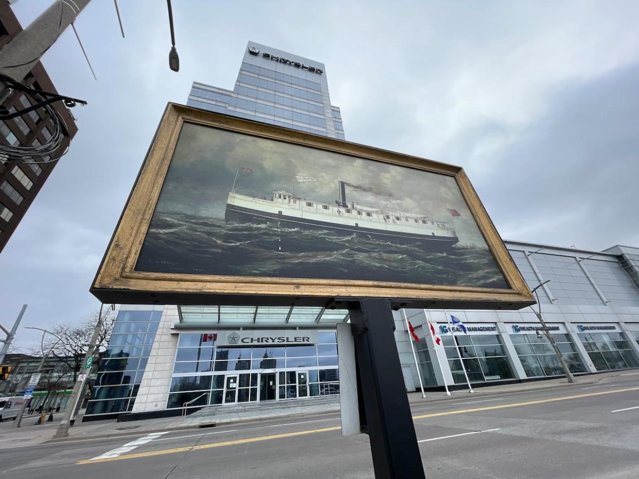 A framed reproduction art piece stands at the corner of Riverside Drive and Ouellette Avenue.  (Chris Ensing/CBC - image credit)