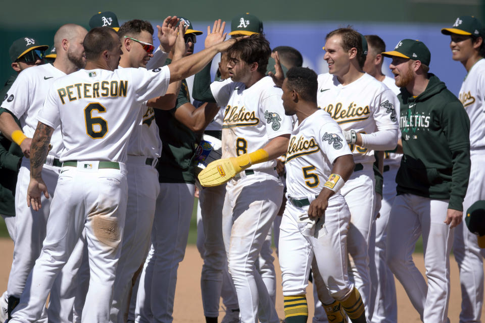 Oakland Athletics' Tyler Wade (8) is mobbed by his teammates after scoring the winning run against the Chicago White Sox during the tenth inning of a baseball game, Saturday, July 1, 2023, in Oakland, Calif. The A's won 7-6. (AP Photo/D. Ross Cameron)