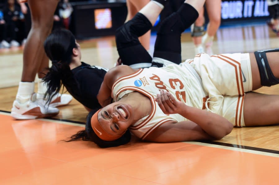 Texas forward Aaliyah Moore (23) reacts after falling to the court during the second half of the team’s Sweet 16 college basketball game against Gonzaga in the women’s NCAA Tournament, Friday, March 29, 2024, in Portland, Ore. Moore was called for a foul on Gonzaga guard Kayleigh Truong. (AP Photo/Steve Dykes)