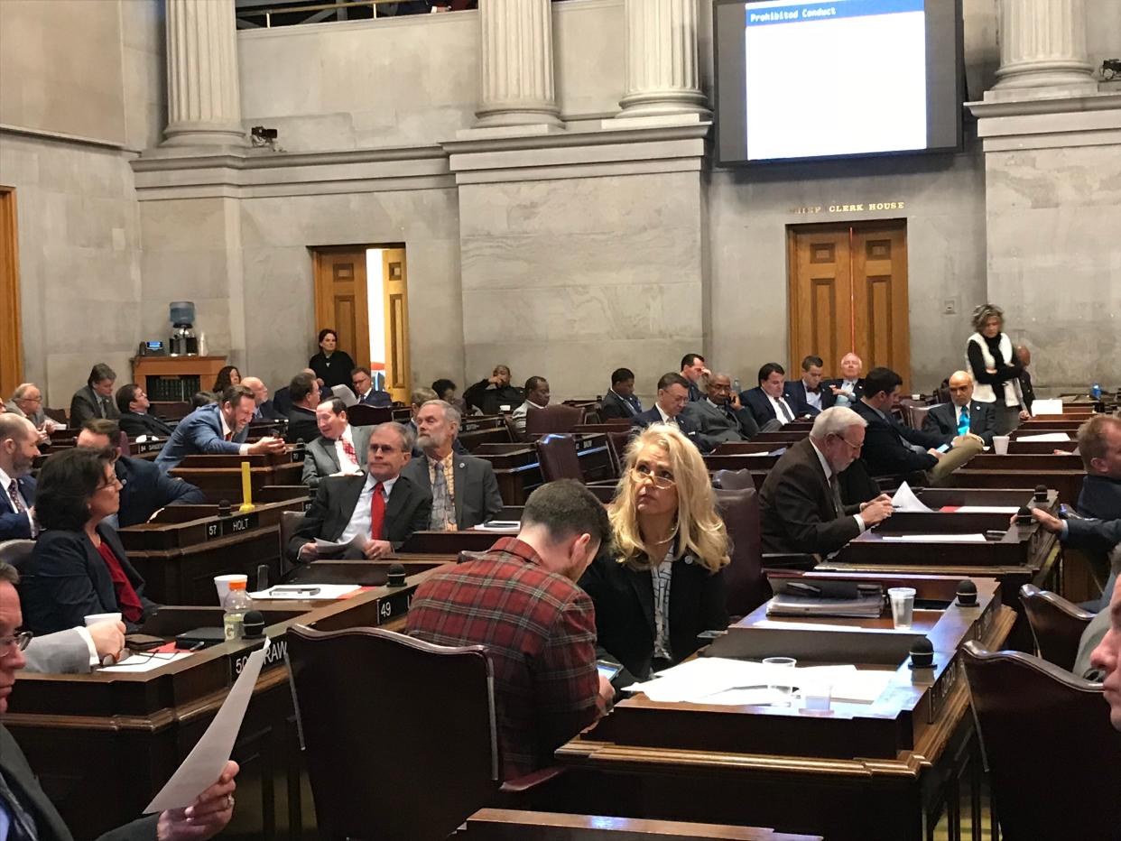 Rep. Robin Smith, center, looks at an overhead presentation while Rep. Michael Curcio, wearing a red jacket uses phone, during a sexual harassment training for the Tennessee House of Representatives on Jan. 10, 2019.