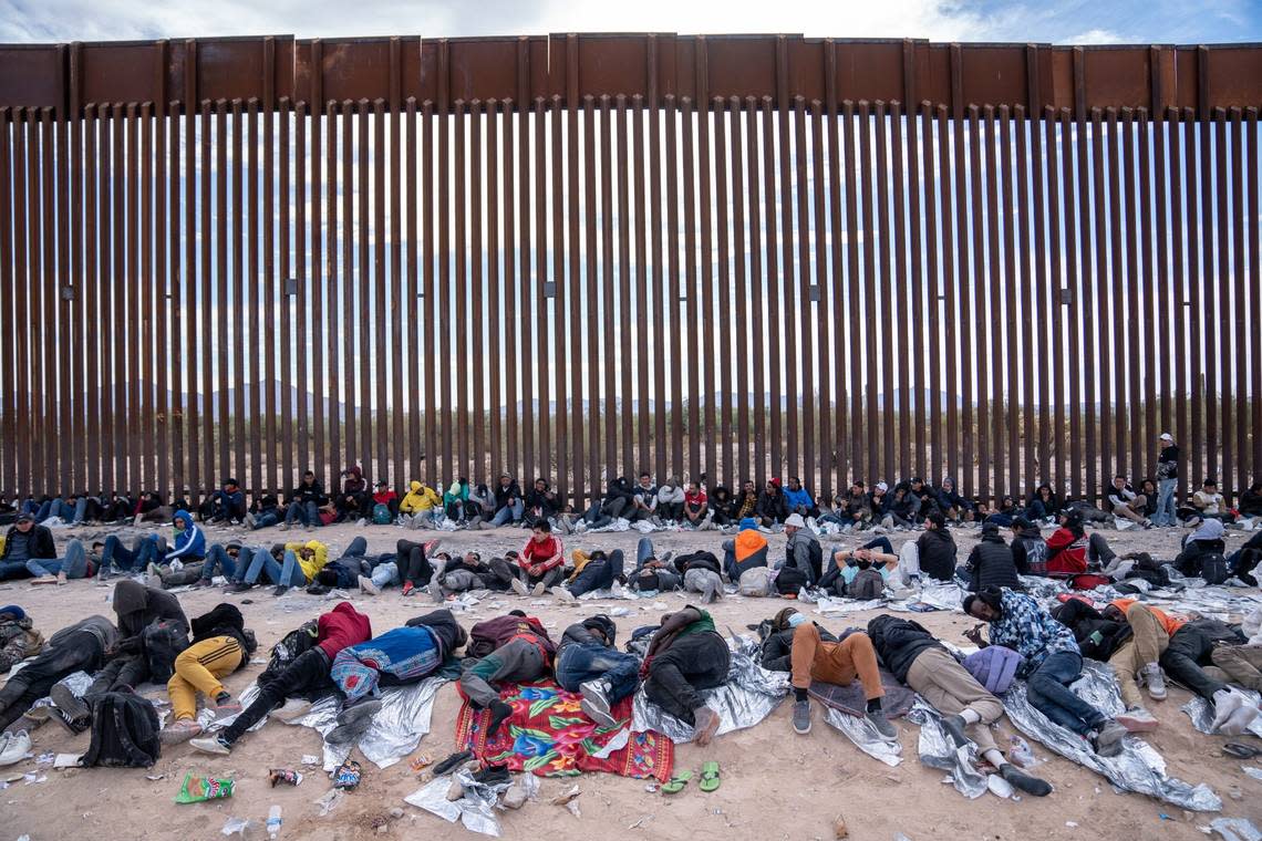 Migrants and asylum seekers wait to be picked up and processed by U.S. Border Patrol agents in Organ Pipe Cactus National Monument along the U.S.-Mexico border about a mile west of Lukeville, Ariz., on Dec. 4, 2023. The Lukeville Port of Entry was closed indefinitely by officials on Dec. 4. Joel Angel Juarez/The Republic / USA TODAY NETWORK