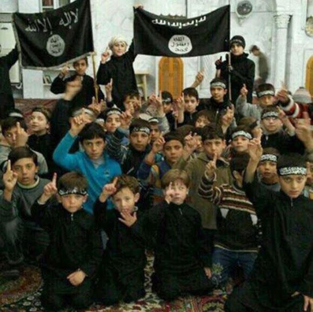 Children pose with Islamic State group flags in Raqqa, Syria. Photo: AP/Raqqa Is Being Slaughtered Silently