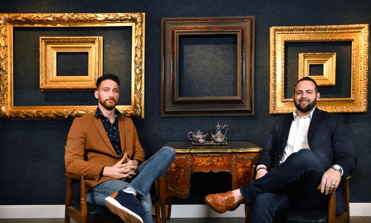 Brandon Stone, left, and Austin Helmuth sit in their downtown Sarasota gallery with a few of the more than 500 period frames from the collection of Eli Wilner that will be auctioned later this month.