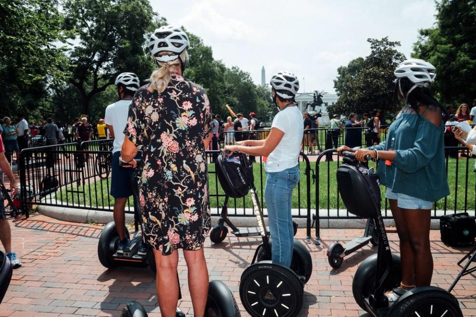 A group of passersby on scooters at Lafayette Square.