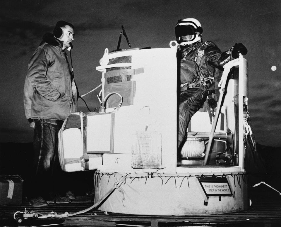 FILE - In this photo provided by the U.S. Air Force, Capt. Joseph Kittinger Jr., aerospace laboratory test director, sits in the open balloon gondola after his first parachute test jump for Project Excelsior at the Air Force Missile Development Center, N.M., Nov. 16, 1959. The gondola carried him at an altitude of 76,400 feet for his record free fall jump of more than 12 miles. At left is David Willard, who designed and developed special equipment for the gondola. Kittinger, the U.S. Air Force pilot who held the record for the highest parachute jump for more than 50 years, died Friday, Dec. 9, 2022, in Florida at age 94. (AP Photo/File)