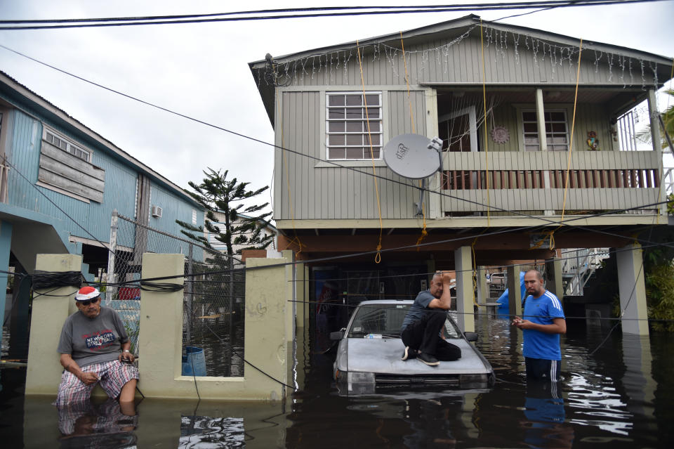 <p>Inhabitants stand in flood water in front of a house flooded in Juana Matos, Catano, Puerto Rico, on Sept. 21, 2017. (Photo: Hector Retamal/AFP/Getty Images) </p>