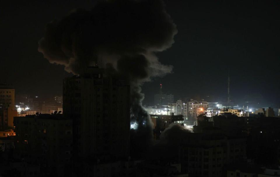 Smoke and flames rise after Israeli forces strike targets in the Gaza Strip on Sunday.