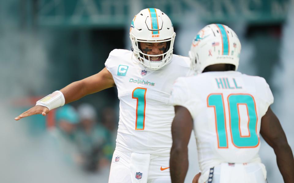 Miami Dolphins quarterback Tua Tagovailoa (1) and wide receiver Tyreek Hill (10) take the field before the opening game of the season against the New England Patriots at Hard Rock Stadium in Miami Gardens, Sept. 11, 2022. 