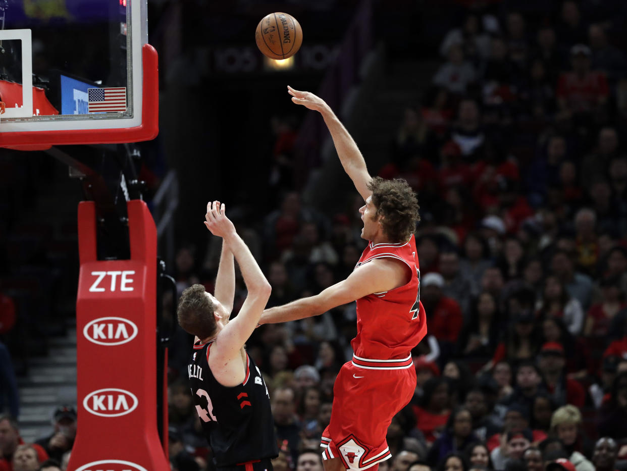 Bulls center Robin Lopez (right) shoots against Raptors center Jakob Poeltl. (AP)