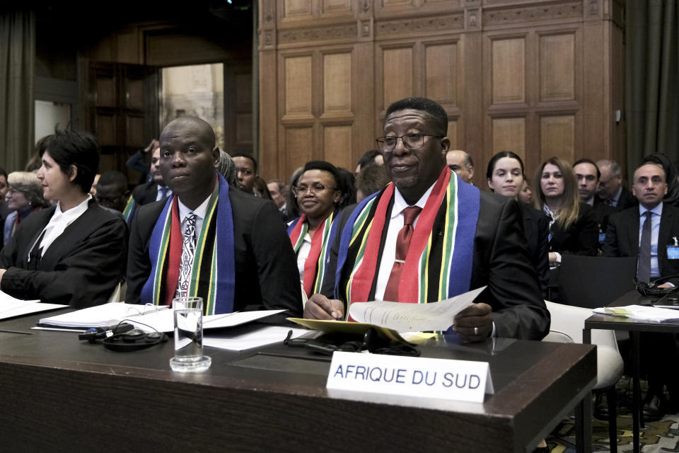 Ambassador of the Republic of South Africa to the Netherlands Vusimuzi Madonsela, right, and Minister of Justice and Correctional Services of South Africa Ronald Lamola, center, during the opening of the hearings at the International Court of Justice in The Hague, Netherlands, Thursday, Jan. 11, 2024. The United Nations' top court opens hearings Thursday into South Africa's allegation that Israel's war with Hamas amounts to genocide against Palestinians, a claim that Israel strongly denies. (AP Photo/Patrick Post)