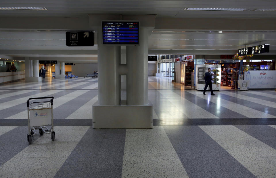 An officer walks through the almost empty arrival hall of the Rafik Hariri International Airport during a strike in Beirut, Lebanon, Friday, Jan. 4, 2019. Parts of Lebanon's public and private sectors have gone into a strike called for by the country's labor unions to protest worsening economic conditions and months of delays in the formation of a new government. (AP Photo/Bilal Hussein)