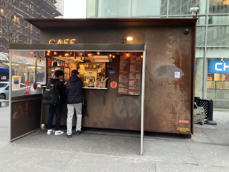 <p>A sample photo from the iPhone SE (2022) featuring a small outdoor coffee stand.</p>
