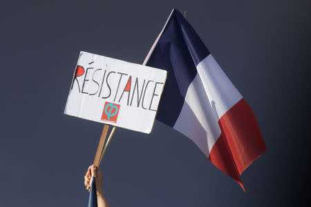 A protestor holds a French flag and a banner of the "France Insoumise" (France Unbowed) party reading: "Resistance" during a demonstration against the government's labour reforms in Paris, France, September 23, 2017. REUTERS/Philippe Wojazer