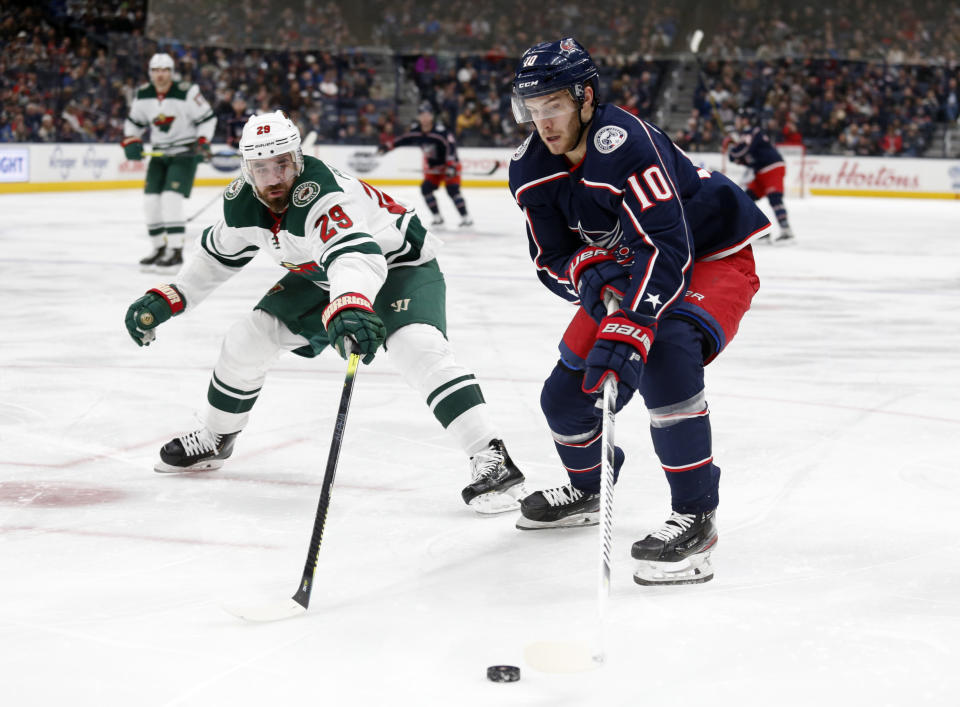 Columbus Blue Jackets forward Alexander Wennberg, right, of Sweden, controls the puck in front of Minnesota Wild defenseman Greg Pateryn during the second period of an NHL hockey game in Columbus, Ohio, Friday, Feb. 28, 2020. (AP Photo/Paul Vernon)