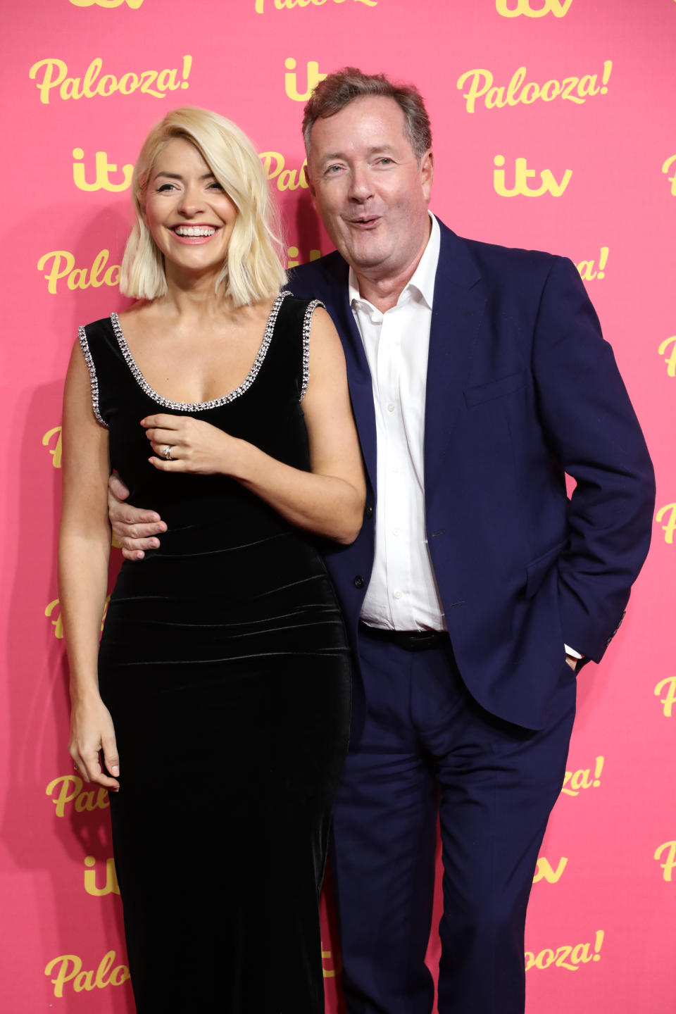 Piers Morgan holds Holly Willoughby's waist as friends poses together