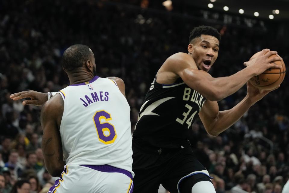 Milwaukee Bucks' Giannis Antetokounmpo looks to shoot past Los Angeles Lakers' LeBron James during the first half of an NBA basketball game Friday, Dec. 2, 2022, in Milwaukee. (AP Photo/Morry Gash)