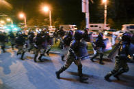 Police run to block protesters during a mass rally following presidential elections in Minsk, Belarus, Monday, Aug. 10, 2020. Thousands of people have protested in Belarus for a second straight night after official results from weekend elections gave an overwhelming victory to authoritarian President Alexander Lukashenko, extending his 26-year rule. A heavy police contingent blocked central squares and avenues, moving quickly to disperse protesters and detained dozens. (AP Photo/Sergei Grits)