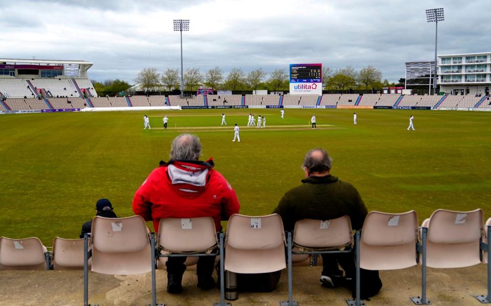 Two spectators watch the action during day one of the County Championship match between Hampshire and Warwickshire at the Utilita Bowl, Southampton on April 19, 2024