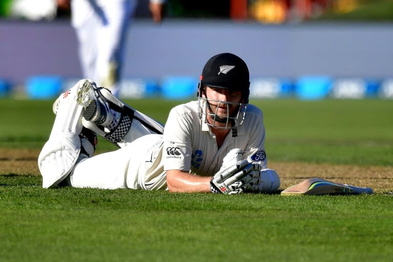 New Zealand's captain Kane Williamson lays on the ground after nearly being run out by South Africa's Kagiso Rabada on day two of their 1st Test match, at the University Oval in Dunedin, on March 9, 2017