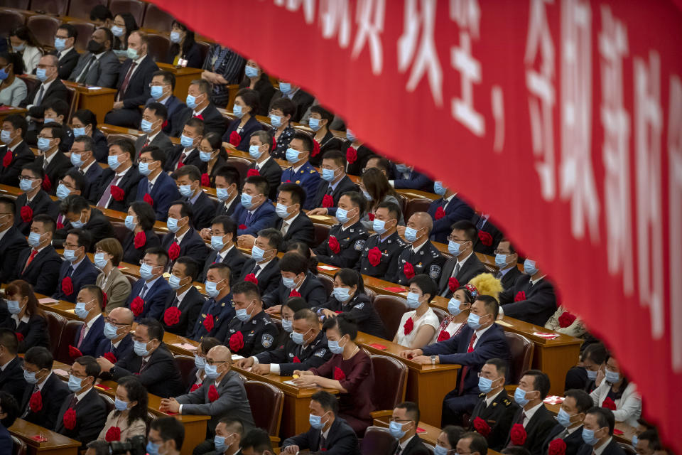 Attendees wearing face masks watch an event to honor some of those involved in China's fight against COVID-19 at the Great Hall of the People in Beijing, Tuesday, Sept. 8, 2020. Chinese leader Xi Jinping is praising China's role in battling the global coronavirus pandemic and expressing support for the U.N.'s World Health Organization, in a repudiation of U.S. criticism and a bid to rally domestic support for Communist Party leadership. (AP Photo/Mark Schiefelbein)