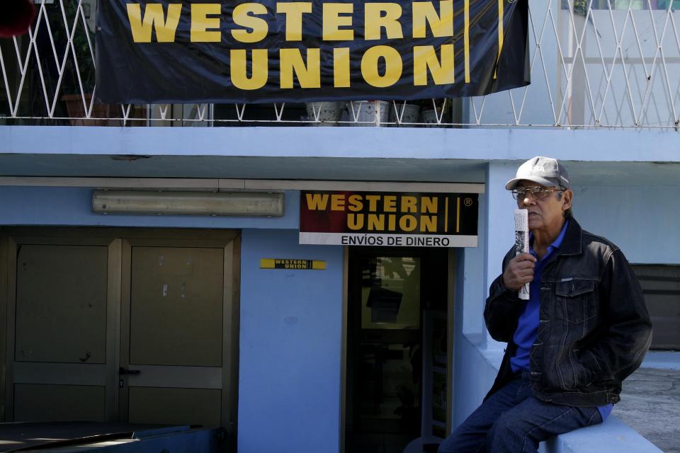 En esta imagen del 28 de diciembre de 2010, Claudio Calderón espera a recibir el dinero que le enviaron sus familiares en Estados Unidos, afuera de una agencia de Western Union en La Habana, Cuba. (AP Foto/Franklin Reyes, Archivo)