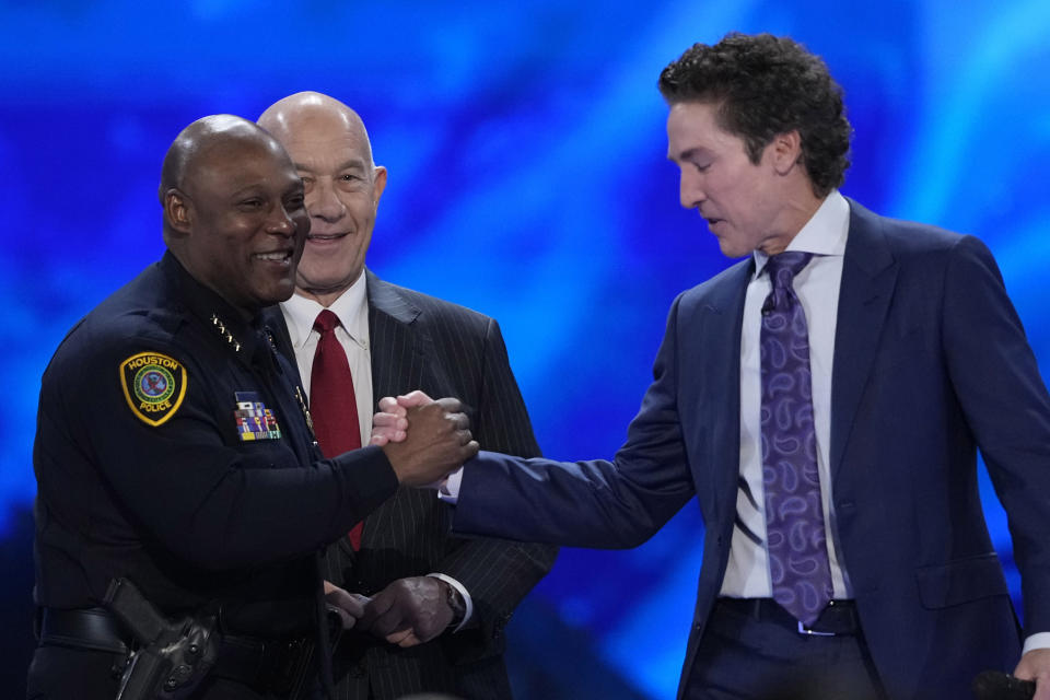 Pastor Joel Osteen, right, shakes hands with Houston Police Chief Troy Finner during a service at Lakewood Church Sunday, Feb. 18, 2024, in Houston. Pastor Osteen welcomed worshippers back to Lakewood Church for the first time since a woman with an AR-style opened fire in between services at his Texas megachurch last Sunday. (AP Photo/David J. Phillip)