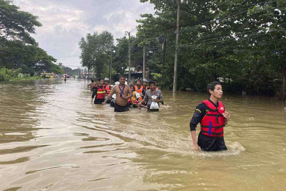 Members of a rescue team carry residents in a boat along a flooded road in Bago, Maynmar, about 80 kilometers (50 miles) northeast of Yangon, Friday, Aug. 11, 2023. (AP Photo)