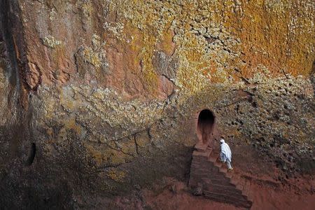 An Orthodox Christian walks into one of 11 monolithic rock-cut churches, ahead of Orthodox Easter in Lalibela in this May 4, 2013 file photo. REUTERS/Goran Tomasevic/Files