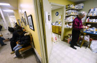 Dr. Ed Jelonek (R) works in his own free time as patients line up outside at the Order of Malta Medical and Dental Clinic for low income Michigan residents in the basement at the St. Leo Catholic Church in Detroit, December 21, 2011. St. Leo Catholic Church, located in one of the most abandoned pockets of the nation's most depressed city, is operating on life support. Built more than 120 years ago as Detroit was developing into a manufacturing powerhouse, St. Leo is one of the many area churches to have succumbed to a same priest and parishioner shortage that has plagued the Catholic Church in America. REUTERS/Mark Blinch