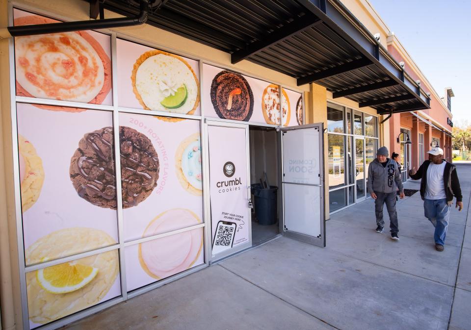 Construction workers make their way into the new Crumbl Cookies, which will be opening soon at suite 320B at Market Street at Heath Brook mall in southwest Ocala.