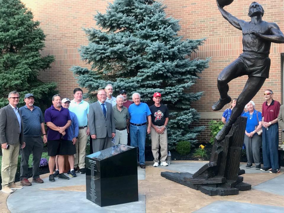 The committee led by Bruce Caplinger poses with the statue of Neil Johnston in front of Chillicothe High School's Gymnasium.