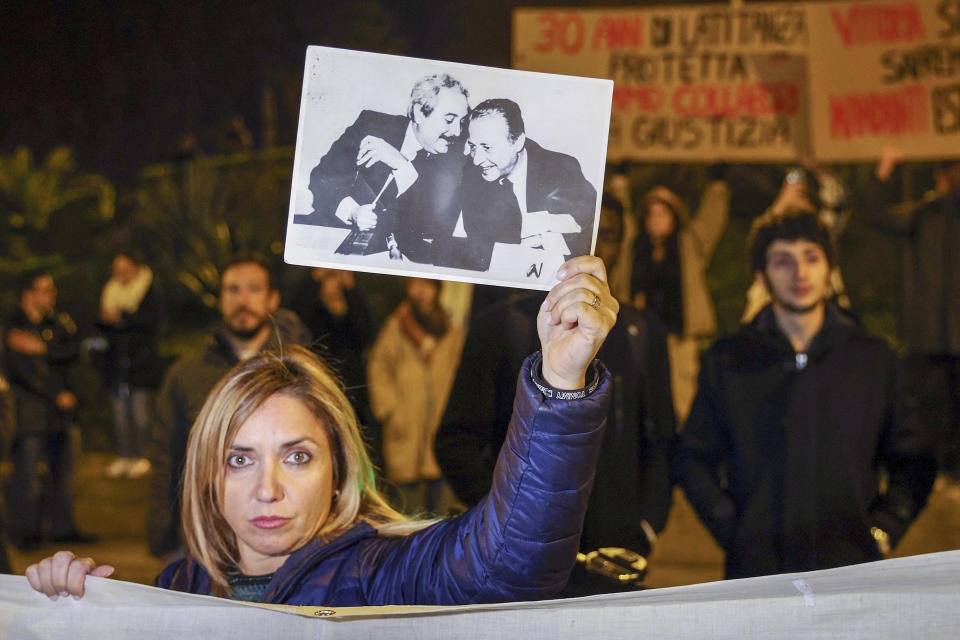 FILE - A woman displays a photograph that became iconic in Italy and shows top anti-mafia prosecutors Giovanni Falcone, left, and Paolo Borsellino, during a demonstration in the streets of Palermo, Sicily, Italy, Monday, Jan. 16, 2023, the day Italy's No. 1 fugitive, Mafia boss Matteo Messina Denaro, was arrested at a private clinic in the Sicilian town, after 30 years on the run. Messina Denaro, a convicted mastermind of some of the Sicilian Mafia’s most heinous slayings, died on Monday, Sept. 25, 2023, in a hospital prison ward, several months after being captured as Italy’s No. 1 fugitive and following decades on the run, Italian state radio said. (Alberto Lo Bianco/LaPresse via AP, File)