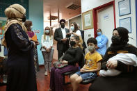 Canadian Minister of International Development Harjit Sajjan, center right, with the Canadian Ambassador to Lebanon Chantal Chastenay, center left, stand next of Syrian refugee women as they listen to Maguy Ghanem a Sexual and Reproductive Health Specialist of United Nations Population Fund (UNFPA), at a women clinic during their visit to Makassed primary health care center, in Beirut, Lebanon, Wednesday, Aug. 17, 2022. Sajjan said Syria is not safe yet for millions of refugees to start returning home and those who fled their homes did so only because they had to. He also said , he also said that Lebanon should work to reach a deal with the International Monetary Fund to start getting the small nation out its worst economic crisis in its modern history. (AP Photo/Hussein Malla)