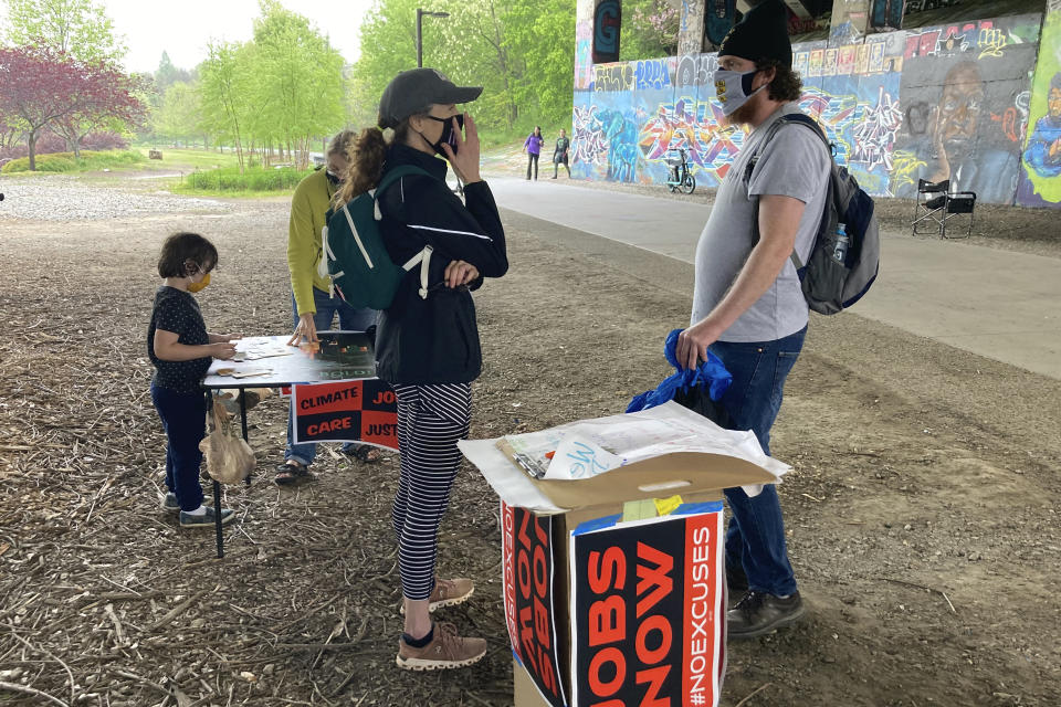 Activist Jan Rivers of Atlanta talks with residents walking along the Atlanta Beltline about progressive movement priorities during an organizing event on April 10, 2021, in Atlanta. Rivers is part of a wide-ranging coalition of progressive organizations trying to pressure Congress on a long list of legislative proposals favored by the left. But the movement faces roadblocks in the evenly divided Senate. (AP Photo/Bill Barrow)