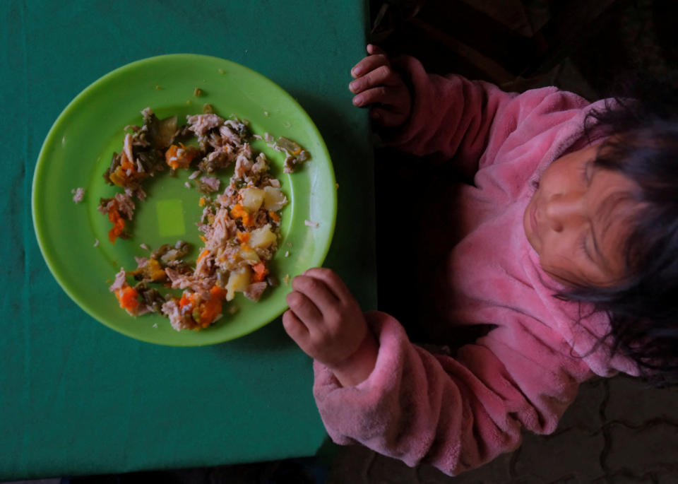 FOTO DE ARCHIVO: Mia Arganaraz, de 1 año, come una ración de guiso en un comedor social donde su madre trabaja como cocinera voluntaria, en Salta, Argentina, el 17 de septiembre de 2024. REUTERS/Javier Corbalan/Foto de archivo