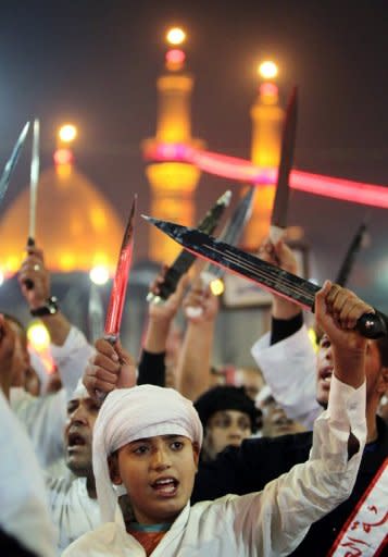 Shiite Muslims raise their swords outside the shrine of Imam Abbas in Karbala on Sunday. Provincial governor Amal al-Din al-Har told AFP that about three million pilgrims, including 200,000 from foreign countries, have come to Karbala for the rituals