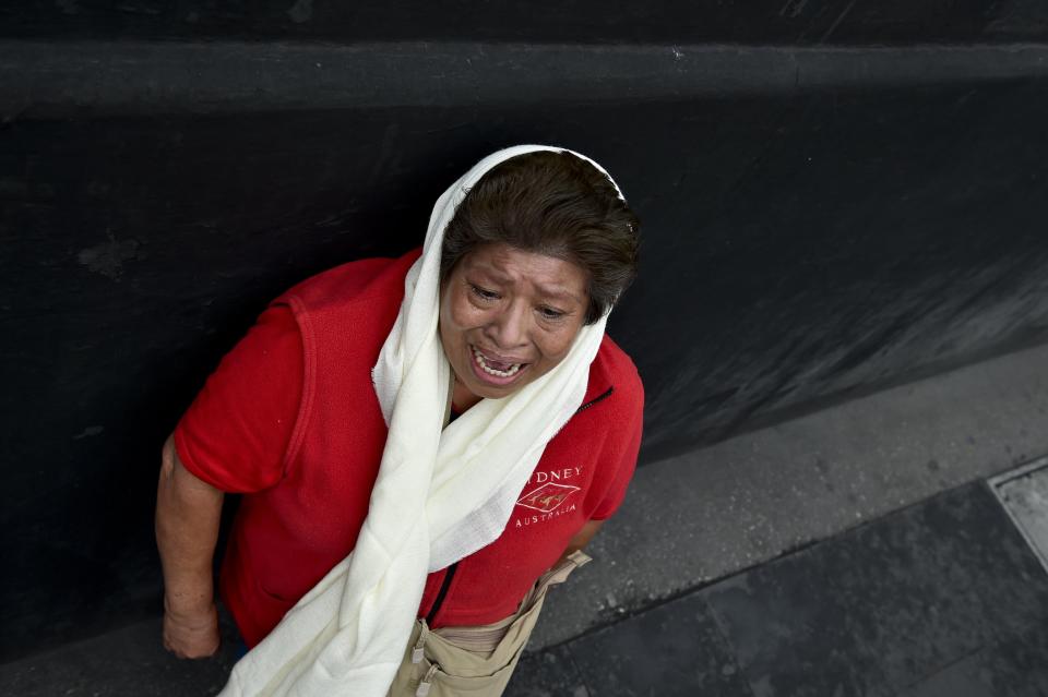 A woman cries as the remains of Mexico's late Latin music legend Juan Gabriel arrive at the Palace of Fine Arts for fans to pay tribute to.