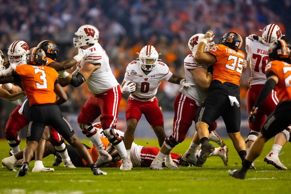 Wisconsin Badgers running back Braelon Allen finds a nice hole to through against Oklahoma State in the first half of the Guaranteed Rate Bowl on  Tuesday.