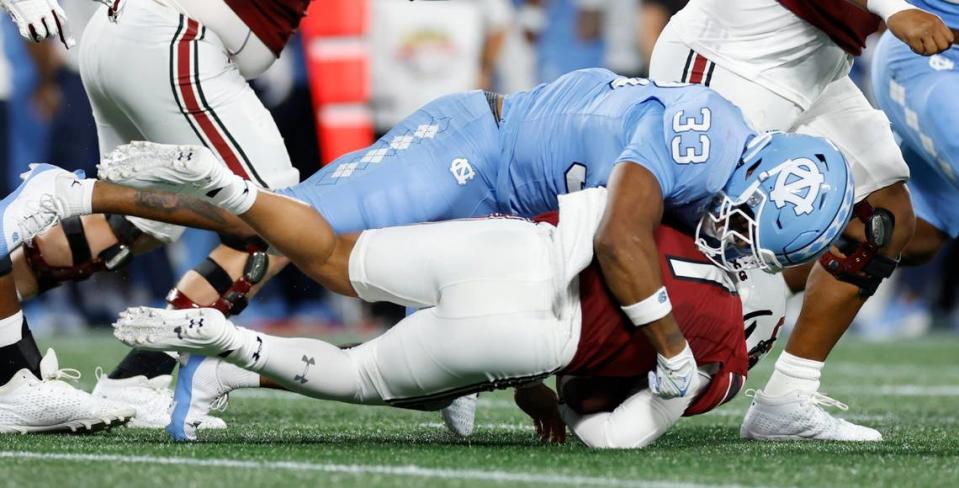 North Carolina linebacker Cedric Gray (33) tackles South Carolina quarterback Spencer Rattler (7) during the first half of UNC’s game against South Carolina in the Duke’s Mayo Classic at Bank of America Stadium in Charlotte, N.C., Saturday, Sept. 2, 2023.