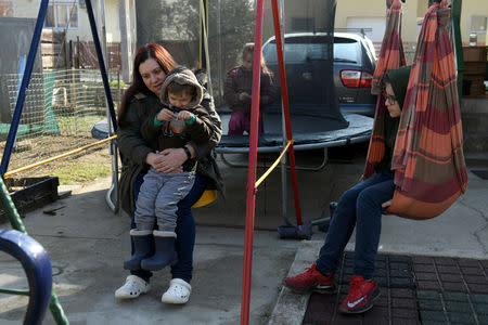 Liza Ludmann-Vank's plays with her children in their yard on the outskirts of Budapest, Hungary, February 16, 2019. Picture taken February 16, 2019. REUTERS/Tamas Kaszas