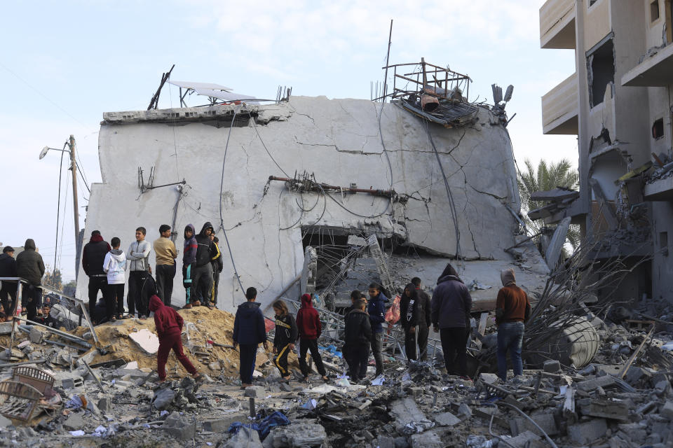 Palestinians look at the destruction after an Israeli strike on a residential building in Rafah, Gaza Strip, Friday, Feb. 16, 2024. (AP Photo/Hatem Ali)