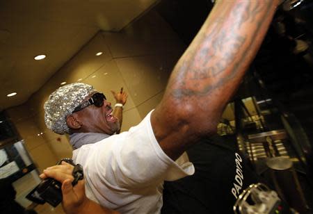 Former basketball star Dennis Rodman of the U.S. gestures as he talks to journalists chasing him upon his arrival at Beijing Capital International Airport September 7, 2013. REUTERS/Kim Kyung-Hoon