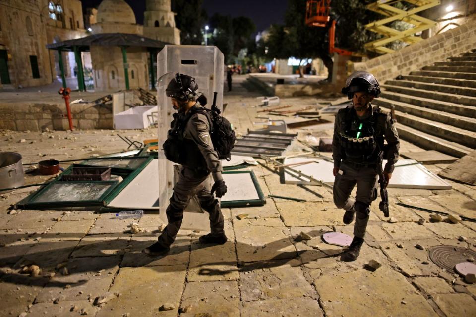 Israeli security forces walk amid debris