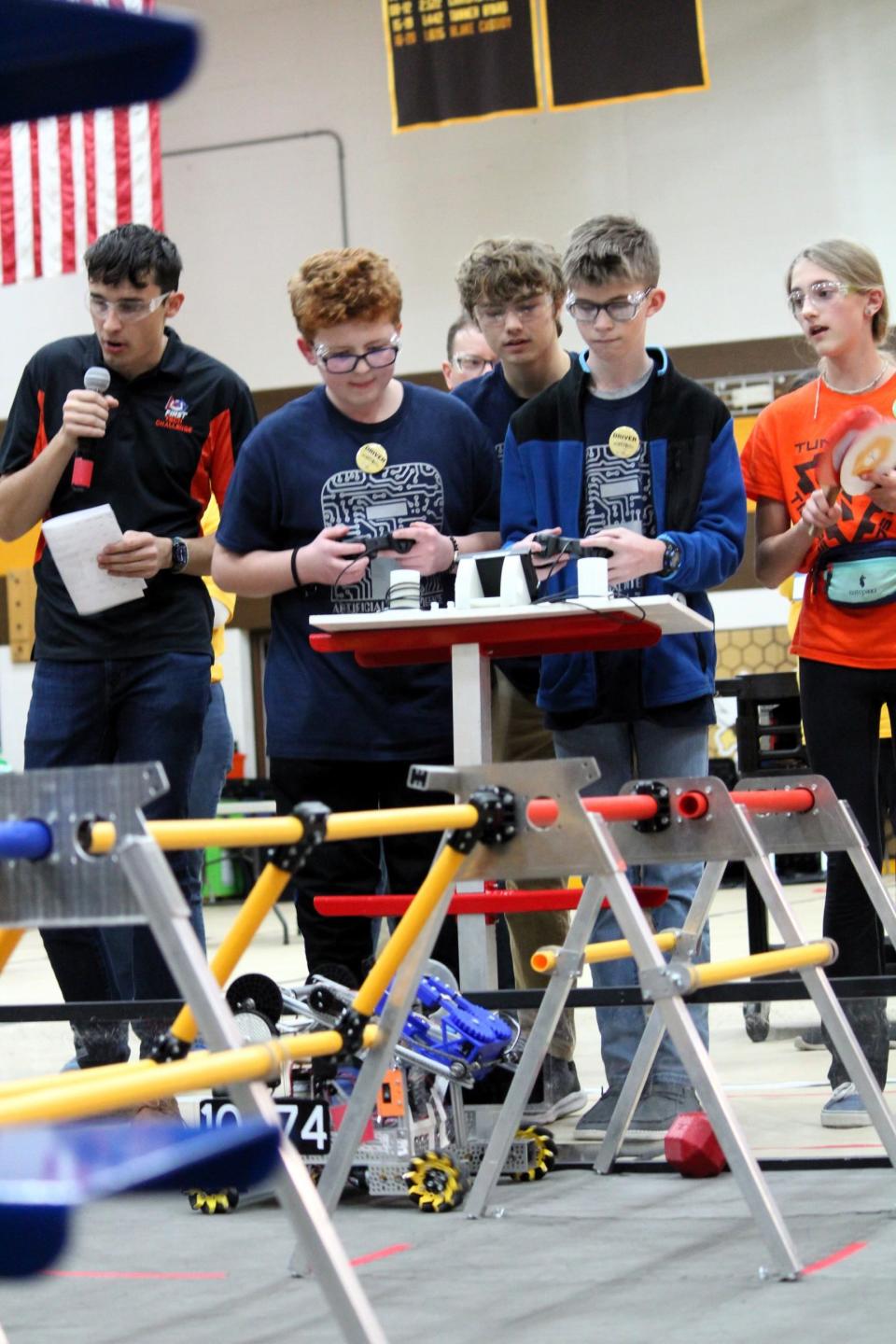 The Pellston drivers control the robot, with the drive team coach overlooking.