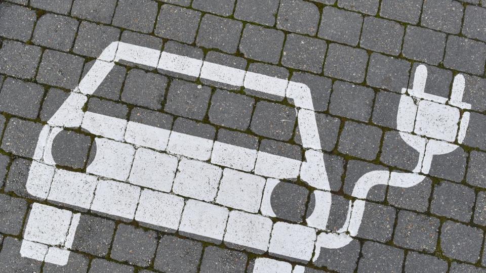 Ein Piktogramm zeigt einen Elektrofahrzeug-Parkplatz. Die Nachfrage nach Elektroautos und Hybriden in Deutschland ist deutlich gestiegen.