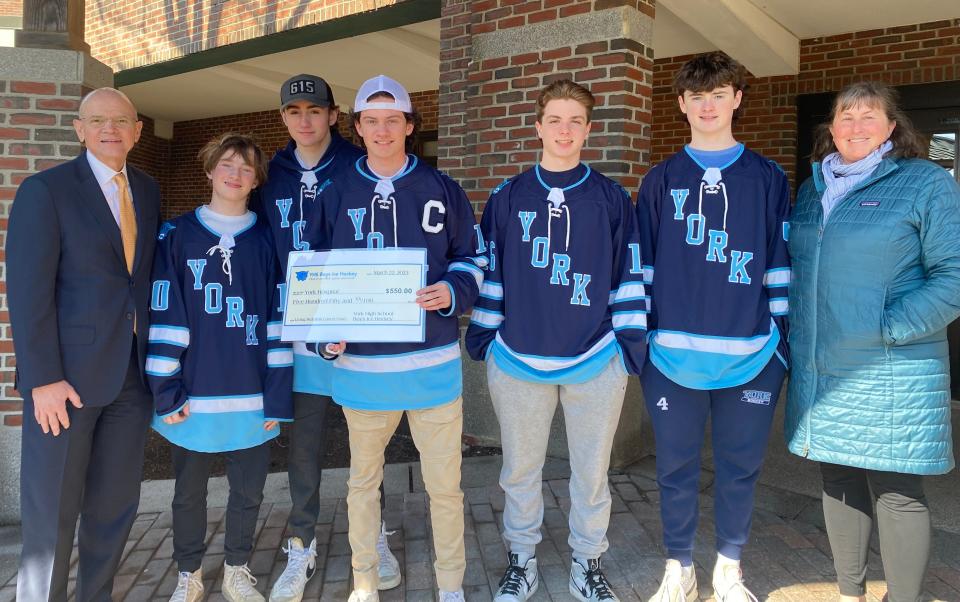 From left to right are Dr. Patrick A. Taylor, York Hospital president & CEO; Jason Woodward, Aiden McQuaide, Russell Henson, Maclain Douris, and Brendan Dowling, from the York High School Boys Hockey Team; and Susan Kelly-Westman, LMSW, York Hospital oncology social worker.