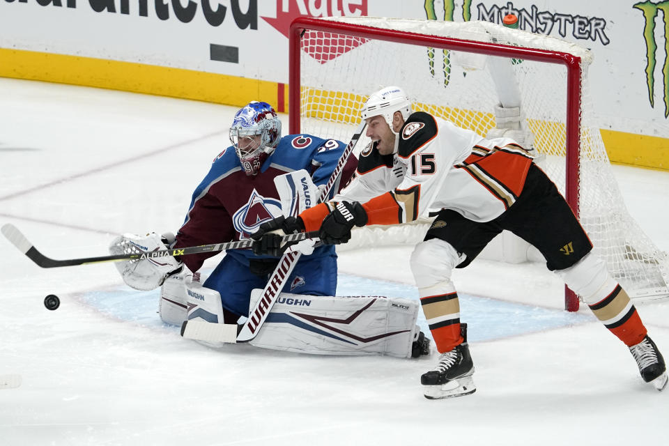 Anaheim Ducks center Ryan Getzlaf, right, tries to redirect a shot as Colorado Avalanche goaltender Pavel Francouz sits in goal during the first period of an NHL hockey game Wednesday, Jan. 19, 2022, in Anaheim, Calif. (AP Photo/Mark J. Terrill)